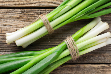 Fototapeta premium Fresh ripe green onions on wooden table, top view