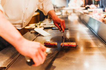 Chef cooks steak on a teppanyaki grill for a delicious meal. Tokyo, Japan