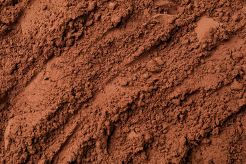 Fototapeta premium Pile of cocoa powder as background, top view