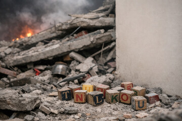 Children&rsquo;s Letter Blocks In Dusty Earthquake Rubble Beside Collapsed Concrete And Smoke