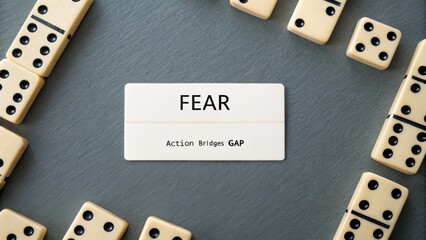Close up of label with word FEAR and dominoes on surface