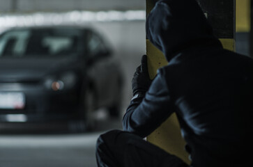 Person Hides in Parking Garage While Watching Parked Car at Night