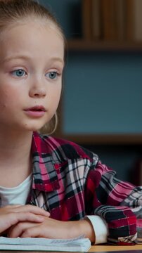 Serious Caucasian kid child girl talking video call with laptop in evening home daughter school pupil studying online distant talk communicate with teacher in conference web class remote education