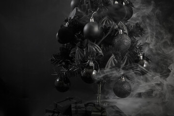Gothic Christmas. A black Christmas tree adorned with dark ornaments and surrounded by mist
