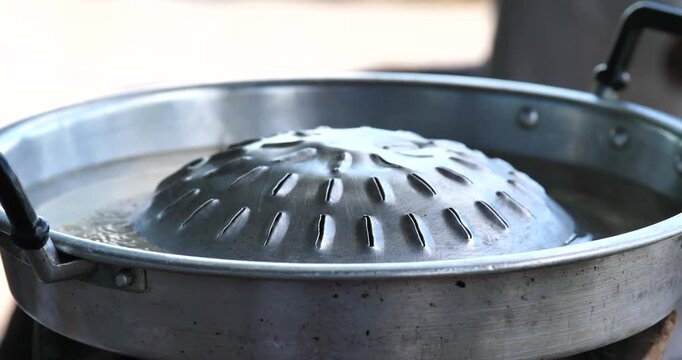 Moo Kata Cooking: A close-up view captures the traditional cooking method of Moo Kata, a culinary tradition that perfectly balances the sizzling of the grill with the warmth of the hot pot.
