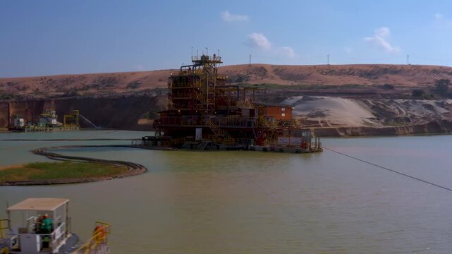 Aerial view of a large industrial structure on water, contrasting with the backdrop of arid land, reflecting the infrastructure's presence, Moma, Nampula Province, Mozambique.