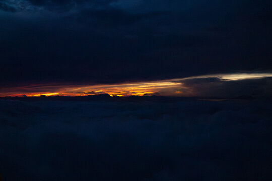 Dawn's Embrace: Witness the dramatic interplay of light and shadow, with the first light of dawn piercing through the clouds, heralding a new day.