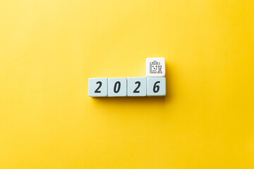 2026 business strategy and tactical planning concept. Wooden cubes showing year 2026 with clipboard and chess piece icon on yellow background. Visionary roadmap for future success and management.