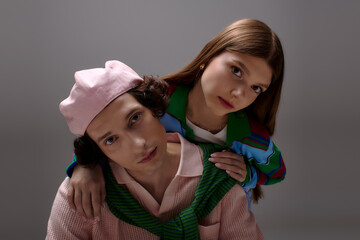 Stylish young couple showcasing modern fashion trends in a cozy studio setting