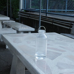 Reusable water bottle on concrete picnic table in urban park outdoor setting