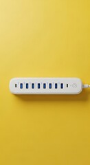 A white USB hub with multiple ports lies horizontally on a bright yellow background. The cable extends to the right