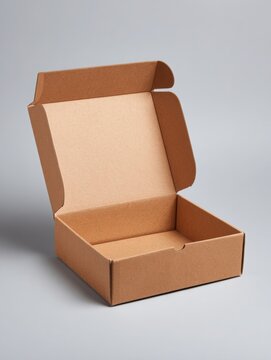 Open empty kraft cardboard shipping box with lid on neutral gray studio background, minimal packaging mockup with copy space, concept of ecommerce delivery