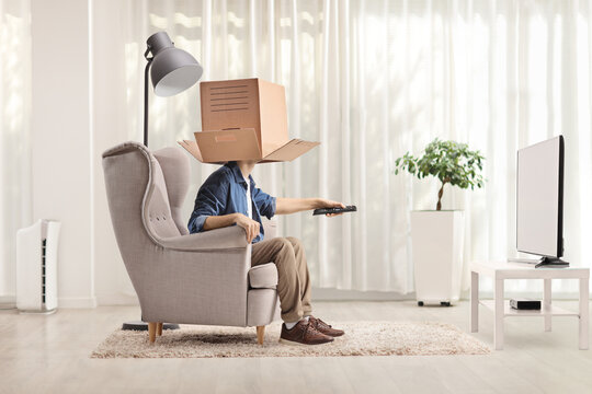 Man in front of tv with a cardboard box over head