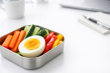 Healthy Lunchbox With Boiled Egg And Fresh Vegetable Sticks On Office Desk