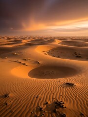 Sand dunes with footprints at sunset in a desert landscape