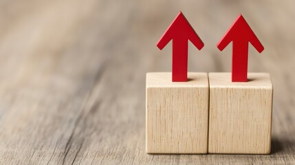 Two red arrows pointing upwards on wooden blocks, symbolizing growth, progress, or positive change in a minimalist setting.