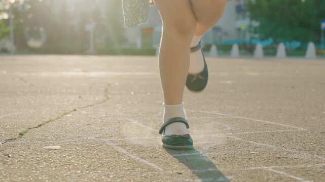 Kid child baby boy girl happy family, child dream, Jumping through numbered squares, Little feet in motion, Street playground adventure, Black shoes and white socks, Concrete play zone, Happy kids on