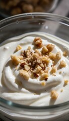 Creamy White Yogurt Topped With Chopped Nuts In A Clear Glass Bowl With Sunlight Streaming Across The Surface