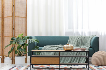 Stylish room with monstera houseplant, comfortable sofa and table. Interior design © New Africa