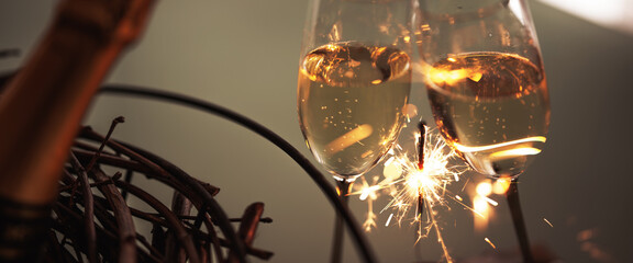 Toasting with champagne glasses and sparklers. Atmospheric horizontaler background for new year and weddings.
