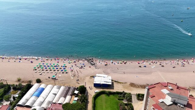Aerial view of Malgrat de Mar beach with tourists and blue sea