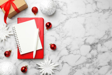 New Year aims. Blank planner, pen and festive decor on white marble table, flat lay. Space for text