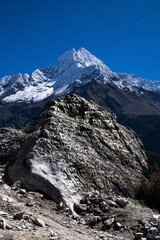 Mani stone with painted and engraved mantra "om mani padme hum" against Mt. Thamserku. Namche bazaar, a capital of Khumbu district, Nepal.