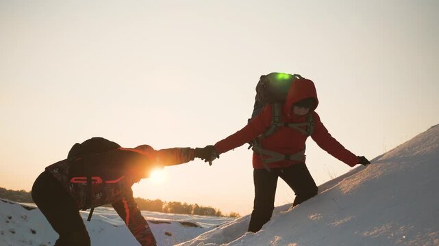 teamwork silhouette. handshake comrades rejoicing victory. shake hands command group mountain hill sunset. overcome difficulties. top cliff goal climbers. trekking snowy winter hike happy successful