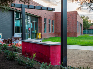 View of a brick building with black accents, a red planter, and fresh landscaping, creating a modern architectural scene, Apollo Park, Oregon, United States.