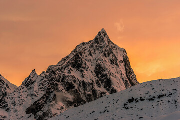 Mt. Cholatse summit at sunset under the colorful orange sky. View from Thokla (Dughla).