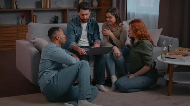 Four multiethnic friends with laptop choosing film online cinema movie at home party discuss order food delivery to domestic event talking looking in computer multiracial diverse men women teamwork