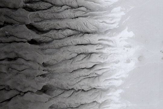 Aerial view of the arid landscape with deep ravines and stark contrasts between light and shadow, Tuzbair, Mangystau Region, Kazakhstan.