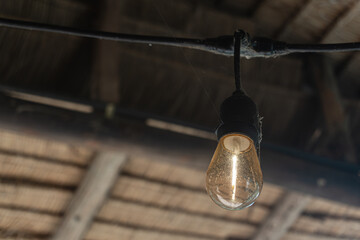 Vintage Light Bulb Hanging from Ceiling in Rustic Interior Space