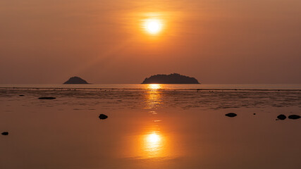 Serene Sunrise Over Tranquil Water with Silhouetted Islands
