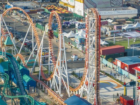 Aerial view of the thrilling Cyclone roller coaster contrasting against the vibrant Coney Island amusement park, Brooklyn, New York, United States.