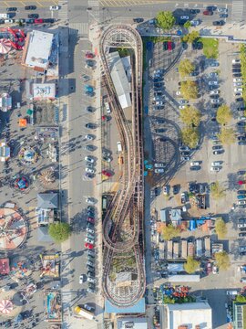 Aerial view of the iconic Coney Island Cyclone roller coaster, a symphony of steel and timber amidst the vibrant hues of the amusement park, Brooklyn, New York, United States.