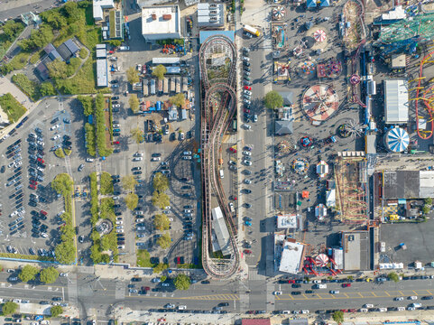 Aerial view of the thrilling Cyclone roller coaster standing tall amidst the vibrant tapestry of Coney Island's amusement parks, Brooklyn, New York, United States.
