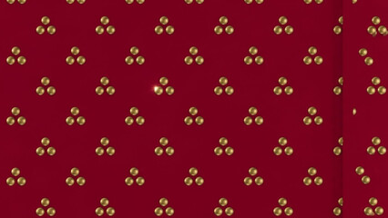 Vibrant red background with clusters of shiny golden beads arranged in a repeating pattern for design and decoration purposes