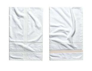 Two folded white bath towels, one with decorative stitching