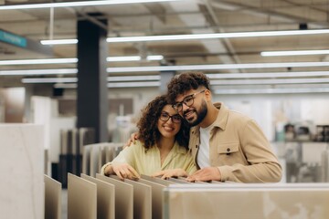 Smiling couple shopping for tiles in home improvement store