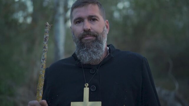PORTRAIT OF A MISSIONARY LOOKING AT THE CAMERA WITH A CROSS AROUND HIS NECK
