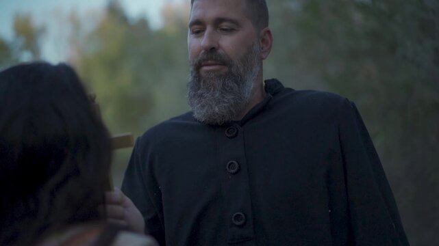 Missionary converts indigenous person to Catholicism by having them kiss the cross