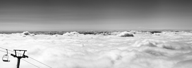 Black and white panorama of mountains under clouds at nice sun day