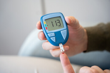 Adult man monitoring glucose levels at home