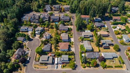 Aerial view of rooftops and lush green trees sprawl across the suburban landscape, a tranquil scene of domesticity under the bright summer sun, Portland, Oregon, United States.