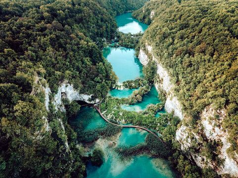 Aerial view of turquoise waters cascading through the lush, green forests and travertine barriers of Plitvice Lakes National Park, Plitvicka Jezera, Lika-Senj County, Croatia.