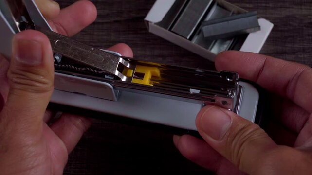 Person Loading a Stapler with Fresh Staples