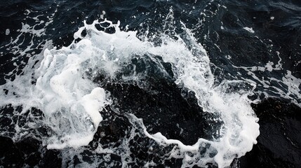 A dramatic, high-angle shot captures a dynamic water splash in dark, choppy water. White foam contrasts with the dark
