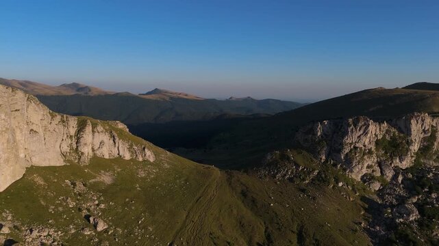 Aerial Pull Away Drone View of Saua Strunga Pass in Bucegi Mountains at Golden Hour with Strungile Mari and Strungile Mici Peaks