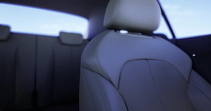 Soft natural light illuminates the interior of a modern car, highlighting the design of a comfortable driver seat with a sleek fabric texture and headrest.